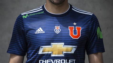 La camiseta es roja con rayas blancas en las mangas y en el pecho igual. Universidad de Chile presenta oficialmente su nueva camiseta | Tele 13