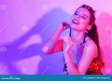 Gorgeous Girl Dancing In A Neon Light A Girl In A Red Shiny Dress And With Cat Ears Is Dancing