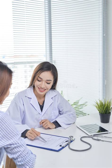 Female Doctor Talks To Female Patient In Hospital Office Stock Image