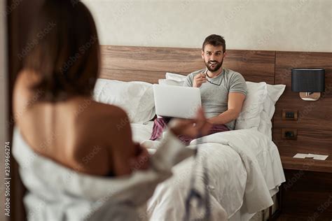 Sexy Woman Trying To Seduce Man Working On Laptop In Bed Stock Photo Adobe Stock