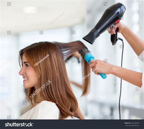Beautiful Woman At The Hairdresser Blow Drying Her Hair Stock Photo