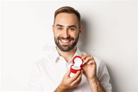close up of happy handsome man making a proposal holding wedding ring