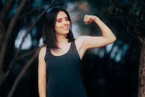 Strong Woman Flexing Her Arm Feeling Fit And Empowered Stock Photo