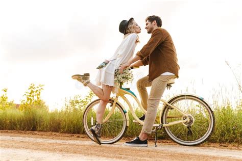 Image Of Young Couple Kissing While Riding Bicycle In Countryside Stock Image Image Of Holiday