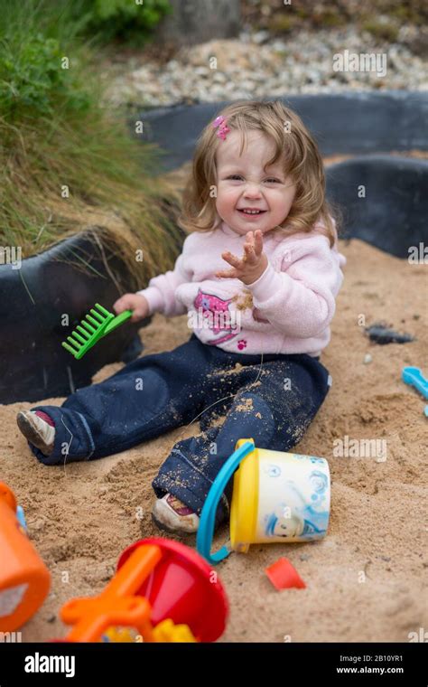 Little Girl Is Playing In The Sandpit Stock Photo Alamy