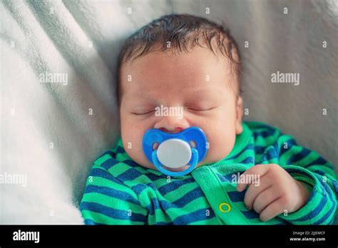 Sleeping Newborn Baby With A Pacifier In His Mouth Close Up Stock Photo