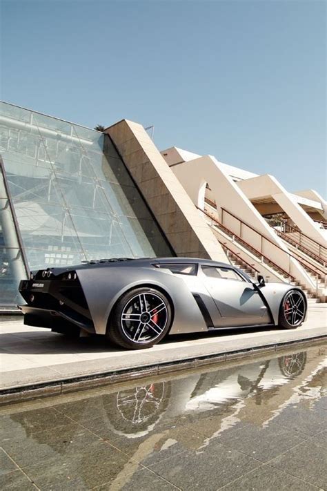 A Silver Sports Car Is Parked In Front Of A Building With Stairs And