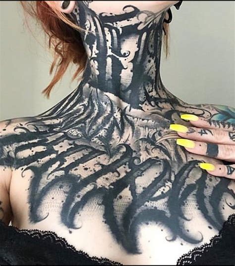 a woman with black and white tattoos on her back neck and shoulders is posing for the camera