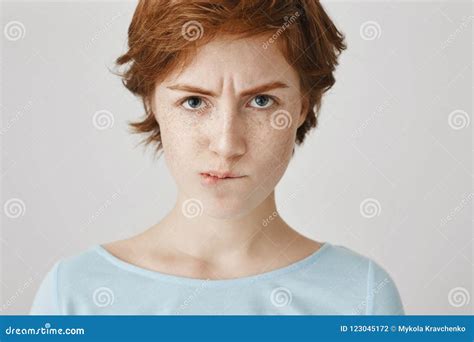Close Up Portrait Of Attractive Angry Redhead Female Looking From Under