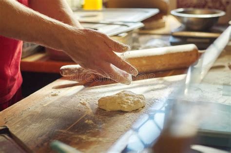 Hands Of Male Baker With Flour Dough Preparing Food On Wooden Table