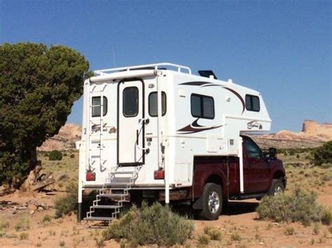 An Rv Parked In The Desert With Its Ladder Up To Its Roof And Stairs Down