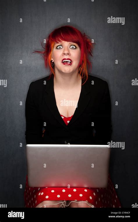 Pretty Punky Girl With Brightly Dyed Red Hair With Laptop Computer