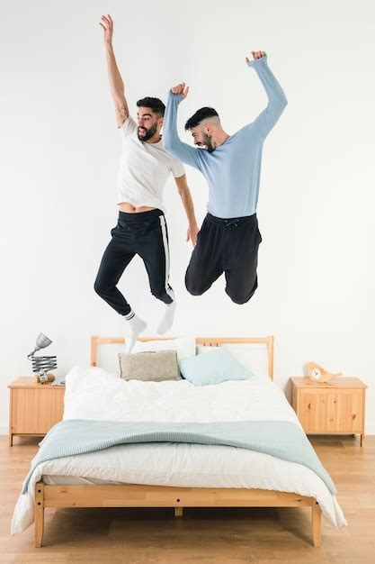 Free Photo Gay Couple Jumping On The Bed In The Bedroom