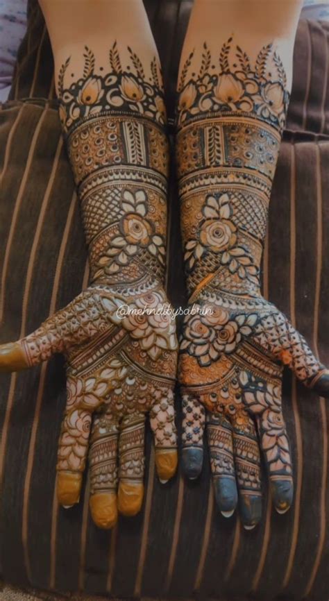 Two Hands With Henna Tattoos On Them Both Showing Their Fingers And Arms Covered In Intricate