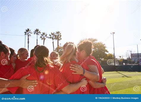 Womens Football Team In Huddle Having Motivational Pep Talk Before