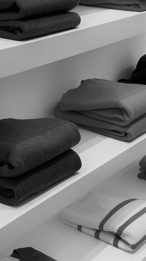 Black And White Photograph Of Folded Clothes On Shelves