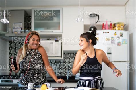 Mother And Daughter Having Fun Together While Dancing In The Kitchen