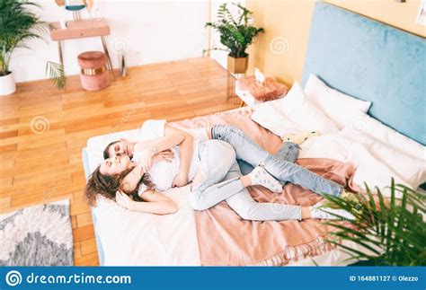 Happy Young Couple On Bed In Bedroom Have Fun Romantic Time Together