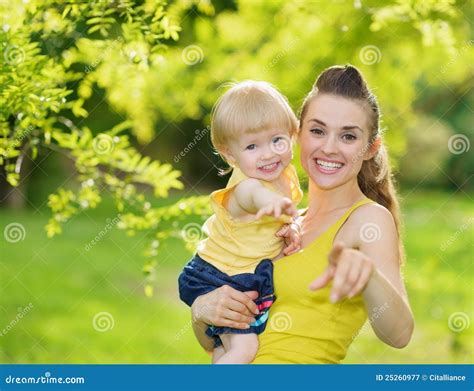 Bebé Y Madre Sonriente Que Señalan En Cámara Imagen De Archivo Imagen