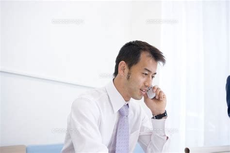 携帯電話で話すスーツの日本人男性[30006002315]の写真素材・イラスト素材｜アマナイメージズ