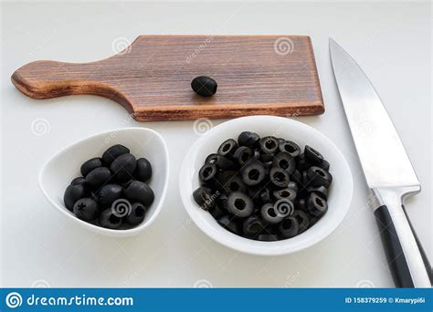 Sliced Olives And Whole Black Olives In A White Bowls Brown Wooden
