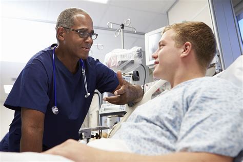 Young Male Patient Talking To Male Nurse In Emergency Room Concentric