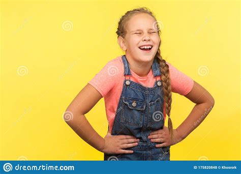 Portrait Of Unhealthy Child With Braid In Denim Overalls Clutching