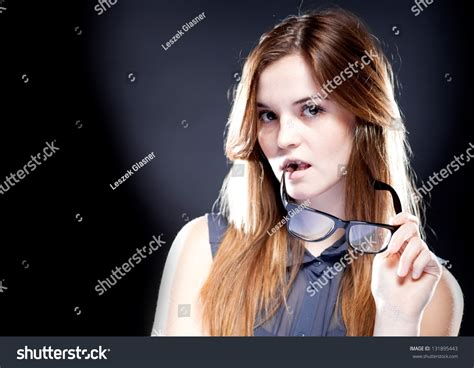 Young Woman Biting A Large Nerd Glasses With Interested Look Stock