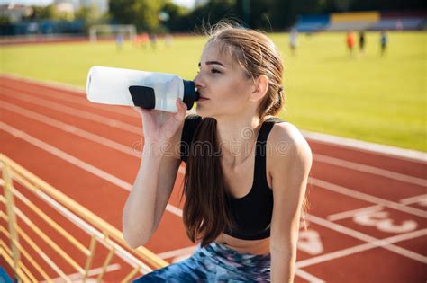 Beautiful Young Tired Fitness Girl Drinking Water After Workout Stock
