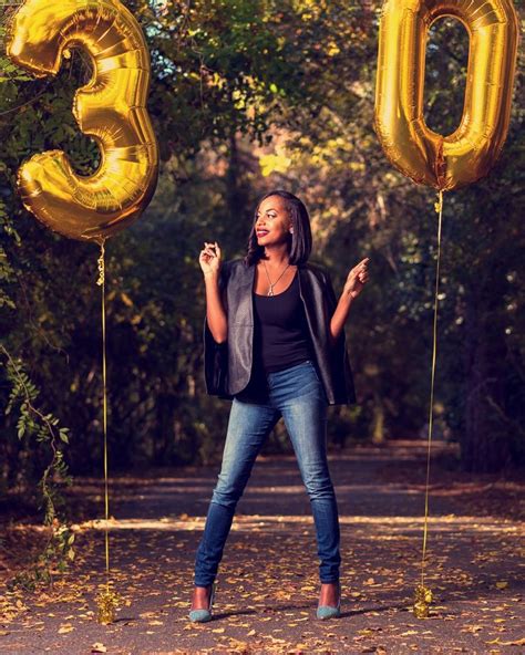 A Woman Standing In Front Of Balloons That Say 30