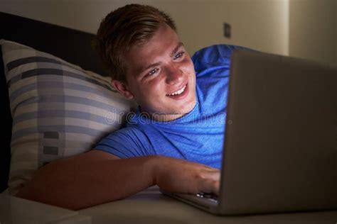 Tiener Die Laptop In Bed Met Behulp Van Bij Nacht Stock Foto Image Of