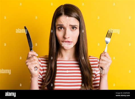 Portrait Of Attractive Girlish Hungry Girl Holding Cutlery Biting Lip Waiting Meal Isolated Over