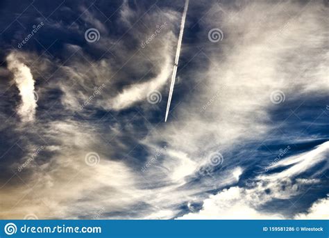 Wide Shot Of The Blue Sky With An Airplane Flying Through The Clouds