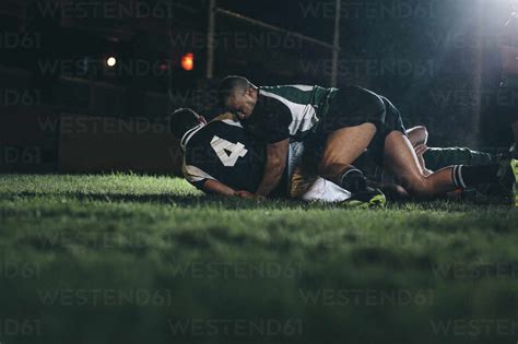 Rugby Players Fight For The Ball On Professional Rugby Stadium Opponent Team Players Striving