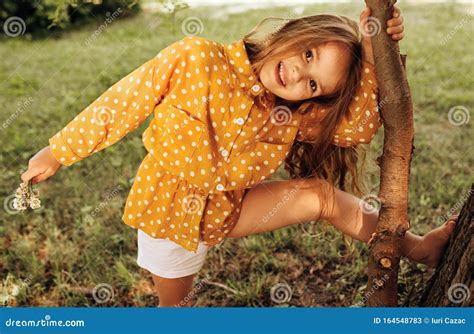 Cheerful Little Girl With Long Blond Hair Playing At Nature Background
