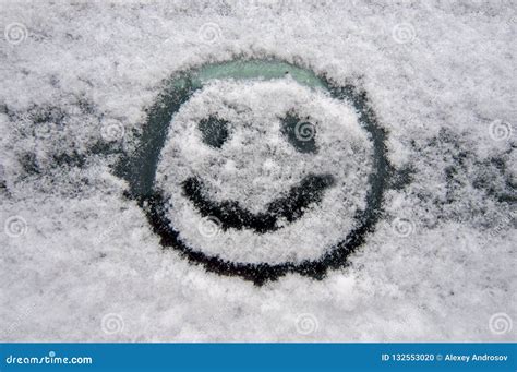 Cheerful Smiley Face On The Snowy Windshield Of A Car Stock Photo