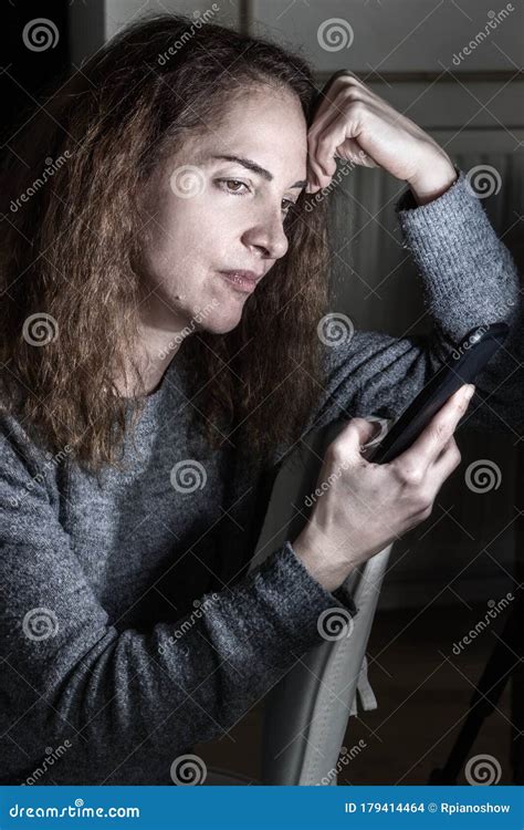 Portrait Of Lonely Mature Woman With Worried Facial Expression Thinking Holding Her Mobile