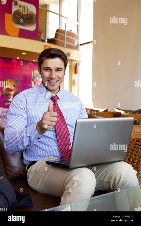 Businessman Working On A Laptop And Showing Thumbs Up Stock Photo Alamy