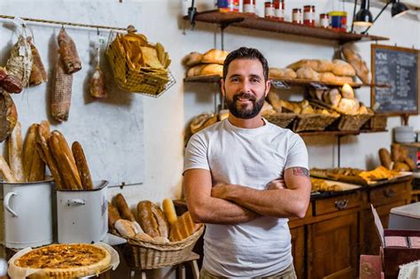 A Man Standing In Front Of Some Breads And Other Food Items On The Shelves