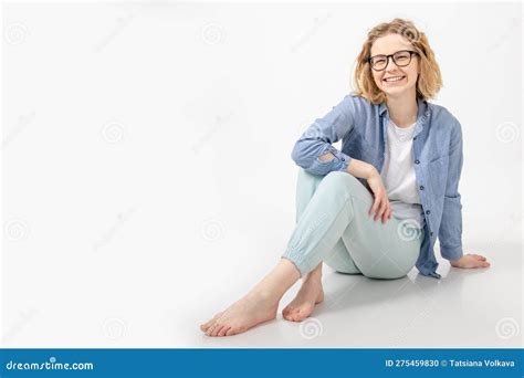 Portrait Of Young Barefoot Woman Sitting With Crossed Legs Looking At