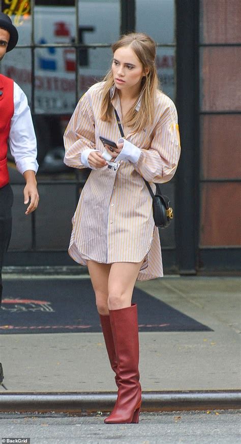 suki waterhouse puts on a very leggy display in a striped t shirt dress and dark red boots