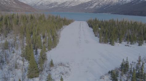 4k Stock Footage Aerial Video Descending Toward Strip Of Snowy Ground