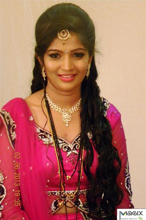A Woman In A Pink Sari Is Posing For The Camera With Her Hair Pulled Back