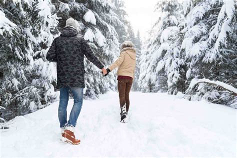 Young Couple Walking In Snow Forest Outdoor Man And Woman Holding Hands