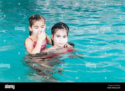 Two Sisters In The Pool Two Happy Girls Play In The Pool Beautiful Girls Swim And Having Fun In