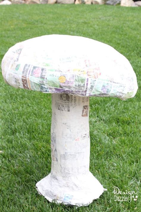 A Paper Mache Mushroom Sitting On Top Of A Green Grass Covered Park