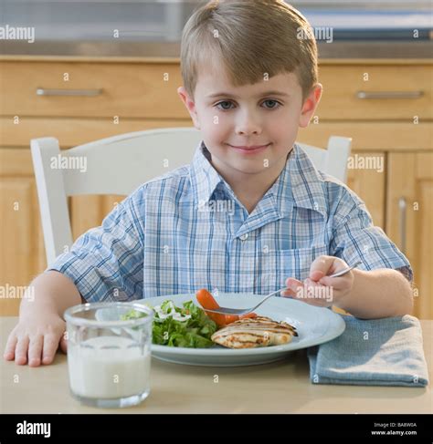 Boy eating dinner Stock Photo - Alamy