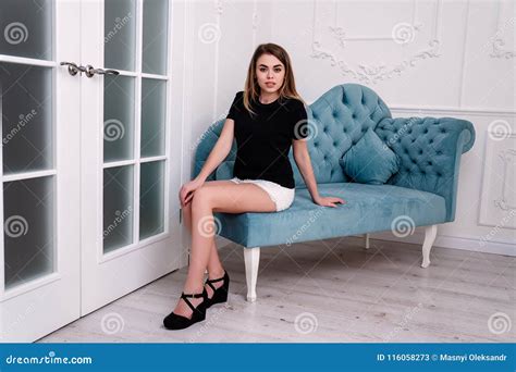 Sentada Modelo De La Muchacha Bonita Joven En Un Sofá Lujoso Imagen de archivo Imagen de