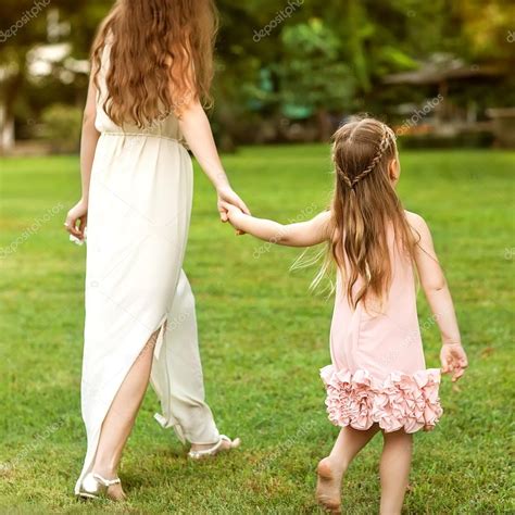 Madre E Hija Caminando Por El Parque Cogidos De La Mano En El Amor