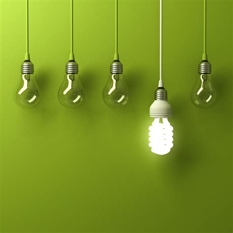 One Hanging Energy Saving Light Bulb Glowing Different Standing Out